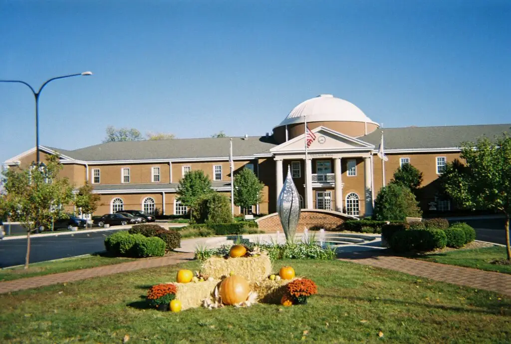 exterior view of addison city hall in Illinois, displaying its classic facade with a grand entrance and an American flag, which had undergone commercial landscaping services .