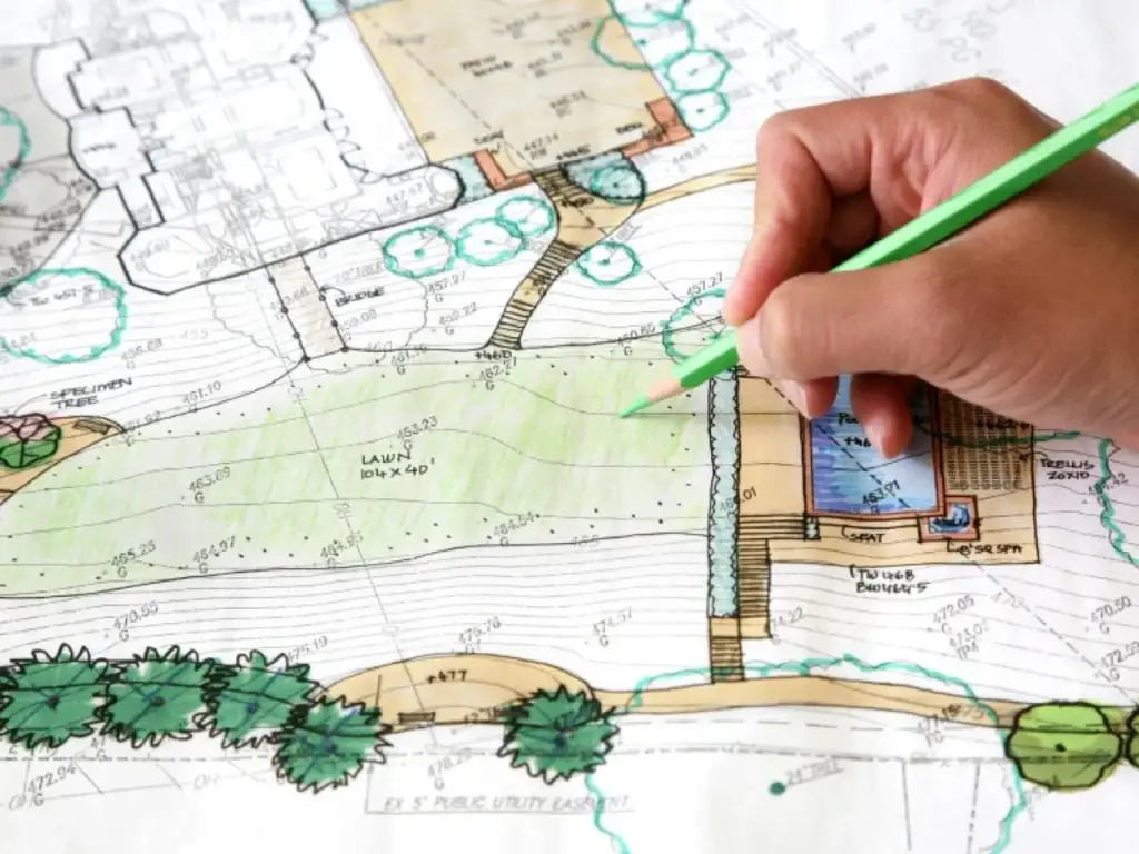 Hand drawing on a landscape plan with green pencil, illustrating creative landscape design ideas.