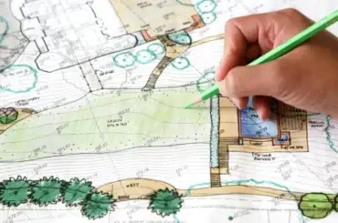 Hand drawing on a landscape plan with green pencil, illustrating creative landscape design ideas.