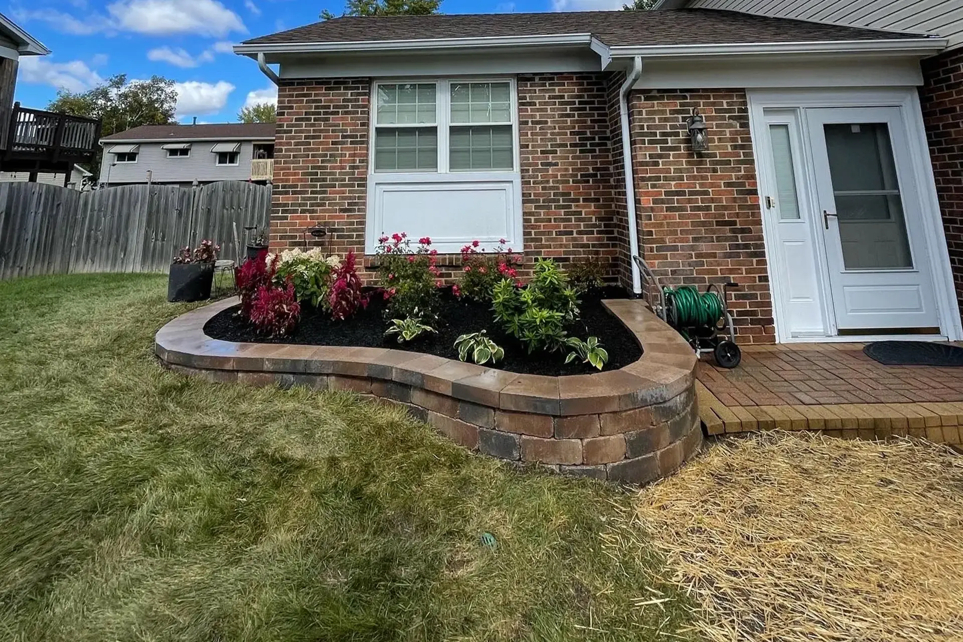 a vibrant front yard landscape in full spring bloom, featuring a lush lawn and a variety of flowering plants