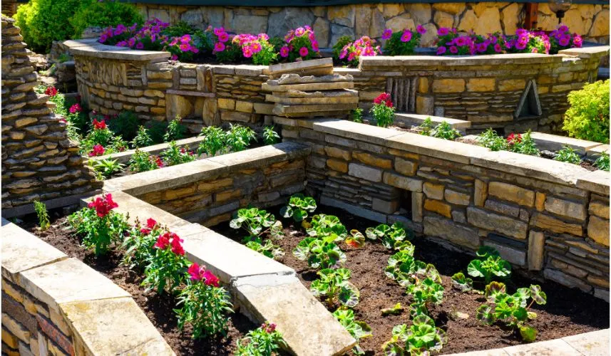 Landscaping with retaining walls and flowerbeds in the house backyard to create an inviting outdoor space.