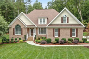 Front yard showing completed landscaping projects with paver walkway, manicured shrubs, and fresh mulch for improved curb appeal.