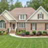Front yard showing completed landscaping projects with paver walkway, manicured shrubs, and fresh mulch for improved curb appeal.